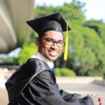 man wearing black graduation gown and cap