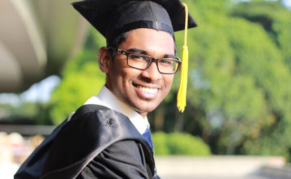 man wearing black graduation gown and cap
